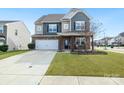 Charming two-story home with a well-manicured lawn, stone accents, and a spacious driveway at 14815 Superior St, Charlotte, NC 28273