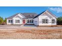 Charming single-story home with white siding, dark shutters, and a bright red front door, set against a sunny sky at 150 Belk Estate Dr, Mooresville, NC 28115