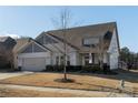 Beautiful single-Gathering home with attached garage, manicured lawn, and charming architectural details at 15035 Batteliere Dr, Charlotte, NC 28278