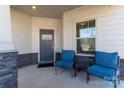 Inviting front porch with blue chairs, stone accents, and a 