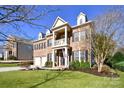 Brick home with dormers and a two-car garage, framed by mature trees and a lush green lawn at 1590 Abercorn Nw St, Concord, NC 28027