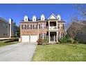 Lovely two-story brick home with a welcoming porch, dormers, and a well-maintained front yard at 1590 Abercorn Nw St, Concord, NC 28027