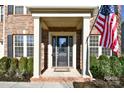 Inviting front entrance with a classic door, sidelights, and manicured shrubs at 1590 Abercorn Nw St, Concord, NC 28027