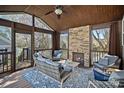 Inviting sunroom with a stone fireplace, comfortable seating, and scenic outdoor views at 16504 Knox Run Rd, Huntersville, NC 28078