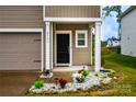 Inviting front door with stone-accented flower beds, covered entry way, and covered area for deliveries at 2131 Belterra Dr, Charlotte, NC 28216