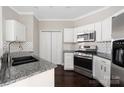 Modern kitchen with stainless steel appliances, granite countertops, and stylish backsplash, ready for cooking at 226 S Torrence St # 303, Charlotte, NC 28204