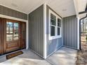 Stylish front door with glass panels, complemented by sleek gray siding and a welcoming entrance mat at 2328 Kingsburry Rd, York, SC 29745