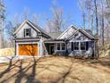 A charming two-story home with a neatly landscaped lawn, wood-tone garage door and a welcoming gray exterior at 2328 Kingsburry Rd, York, SC 29745