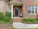 Inviting front entrance with brick steps, a covered porch, and professionally landscaped greenery at 261 Crownsgate Ct, Charlotte, NC 28207