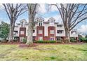 Exterior of condo building featuring well-maintained green spaces with mature trees and lush lawns at 2719 Selwyn Ave # 6, Charlotte, NC 28209
