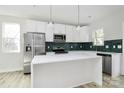 Bright kitchen featuring white cabinets, a center island, stainless steel appliances, and modern light fixtures at 2751 Bradford St, Gastonia, NC 28052