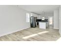Open-concept living area featuring light wood floors and ample natural light from large windows at 2751 Bradford St, Gastonia, NC 28052