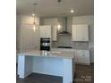 Modern kitchen with stainless steel appliances, a spacious island, and stylish pendant lighting at 305 Basil Dr, Indian Trail, NC 28079