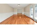 Spacious living room with hardwood floors, wainscoting, and bright natural light at 3200 Highview Rd, Charlotte, NC 28210