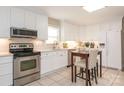 Bright kitchen featuring stainless steel appliances, white cabinets, a stylish faucet, and a cozy breakfast nook at 3711 Davis Dr, Charlotte, NC 28270