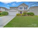 Charming two-story home featuring a well-manicured lawn, beautiful landscaping, and a classic design with a red front door at 433 Annaberg Ln, Monroe, NC 28110