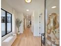 Bright foyer featuring hardwood floors, a modern mirror, and a view into the living area at 4808 Doris Ave, Charlotte, NC 28205