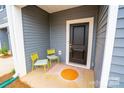 Cozy front porch featuring a bright rug, 2 yellow chairs, and a black door at 508 Tayberry Ln, Fort Mill, SC 29715