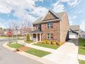 Well-maintained home exterior featuring brick facade, red shutters, and manicured lawn at 6332 Kennard Dr, Charlotte, NC 28216