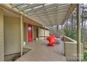 Cozy covered patio with red door, modern furniture and view of surrounding trees at 6366 Sharon Hills Rd, Charlotte, NC 28210