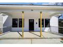Covered front porch of a home with white siding, black windows, and a sleek black front door at 66 Reed Ne St, Concord, NC 28025
