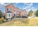 Brick home featuring a manicured lawn, garden beds, and a covered front entrance at 768 Knightswood Rd, Fort Mill, SC 29708