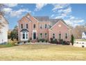 Two-story brick home featuring a manicured lawn, mulched flower beds, and a welcoming front entrance at 768 Knightswood Rd, Fort Mill, SC 29708