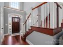 Bright foyer boasts wood floors, staircase with white railing, and arched entry door with sidelights at 8018 Cotton St, Harrisburg, NC 28075