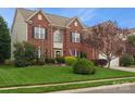 Two-story brick home with manicured lawn and mature landscaping under a blue sky at 809 Circle Trace Rd, Monroe, NC 28110