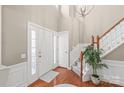 Grand foyer featuring hardwood floors, a staircase with wood railing, and a soaring two-story ceiling with a modern chandelier at 8823 Deerland Ct, Huntersville, NC 28078