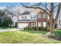 Inviting two-story home with brick and siding facade, showcasing a well-maintained lawn and mature trees at 8823 Deerland Ct, Huntersville, NC 28078