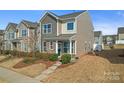 Inviting townhome displaying stone and siding, complemented by lush landscaping in a well-maintained yard at 919 Pennington Dr, Indian Land, SC 29720