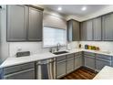 Stylish kitchen features gray cabinetry, white subway tile backsplash and stainless steel dishwasher at 10436 Cullen Ct, Charlotte, NC 28278