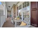 Cozy front porch featuring gray Adirondack chairs with yellow pillows and stylish accents at 10823 Caverly Ct, Huntersville, NC 28078