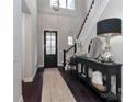 Bright entryway with a dark door, stylish console table, staircase, and dark hardwood flooring at 13306 Old Store Rd, Huntersville, NC 28078