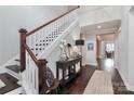 Inviting entryway featuring a staircase with wooden banister, elegant decor, and dark hardwood flooring at 13306 Old Store Rd, Huntersville, NC 28078