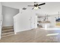 Bright living room with stairs to the left and a view of the white kitchen in the background at 1540 Solitude Ct, Kannapolis, NC 28081