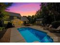 Relaxing backyard featuring an in-ground pool, patio with lounge chairs, and a storage shed at 174 Logan Crossing Dr, Davidson, NC 28036