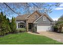 Charming home featuring a stone facade, well-manicured lawn, and a two-car garage at 17701 Springwinds Dr, Cornelius, NC 28031