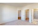 Bedroom with carpet, neutral walls, and doorways to a walk-in closet and en-suite bathroom at 1812 Augustine St, Monroe, NC 28112