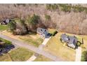 An aerial view shows a tan home's location and large lot, nestled between mature trees and neighboring homes at 2050 Sunswept Ln, York, SC 29745
