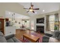Inviting living room features a cozy fireplace, ceiling fan, and seamlessly connects to the kitchen and dining area at 2050 Sunswept Ln, York, SC 29745