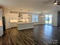 Open-concept living area with stylish pendant lights, dark wood floors, and sliding glass doors at 2084 Fordhill St, Rock Hill, SC 29732