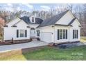 Charming two-story home with white siding, black shutters, attached two car garage and inviting curb appeal at 227 Spicewood Cir, Troutman, NC 28166
