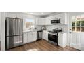Modern kitchen featuring stainless steel appliances, white cabinets, granite countertops and hardwood floors at 2509 Lanecrest Dr, Charlotte, NC 28215