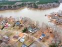 An aerial view of waterfront homes on a lake, featuring private docks and tree lined streets at 265 Sailboat Dr, Salisbury, NC 28146