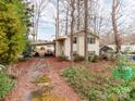 A two story home with a car port is nestled among the trees in this quiet wooded setting at 265 Sailboat Dr, Salisbury, NC 28146