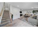 The spacious living room offers a cozy atmosphere with a plush rug, comfortable seating, and staircase access at 2656 Grantham Place Dr, Fort Mill, SC 29715