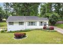Beautiful single-story home featuring a well-manicured lawn with lush landscaping and vibrant flower beds at 3231 Eastwood Dr, Charlotte, NC 28205