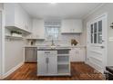 Charming kitchen with white cabinets, movable island and stainless steel appliances at 3231 Eastwood Dr, Charlotte, NC 28205